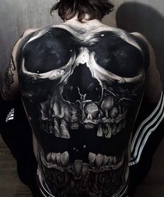 the back of a man with a skull tattoo on it