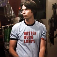 a young man standing in front of a mirror wearing a t - shirt that says mister duck lumps