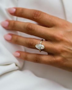 a woman's hand with a diamond ring on it