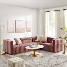 a living room with pink velvet couches and white rugs