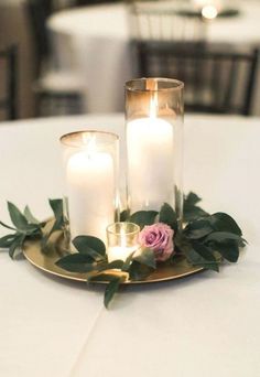 two candles are sitting on a plate with flowers