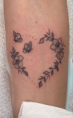 a heart shaped tattoo with flowers on it