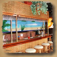 an image of a bar with stools in front of it and a painting on the wall