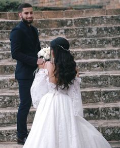 a bride and groom standing in front of some steps