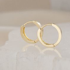 "⚡️ FREE SHIPPING ⚡️ on Domestic orders over $35 🇺🇸 Don't miss out on the opportunity to own a pair of our exquisite Huggie Hoops in solid 14K gold. Upgrade your style and feel the confidence that comes with wearing a piece of jewelry that's as stylish as it is versatile. Get your Modern Huggie Hoops now and let your ears shine with elegance and glamour! * T H E * D E T A I L S *  * Solid 14K Gold * Hoops measure: 10mm - Outside diameter, 7mm - Inside diameter & 1.5mm wide * Posts are 22 gauge Minimalist Adjustable Small Hoop Huggie Earrings, Adjustable 14k Gold Minimalist Huggie Earrings, Adjustable Minimalist 14k Gold Hoop Earrings, Adjustable Everyday Huggie Earrings In 14k Gold Filled, 14k Gold Minimalist Huggie Earrings, Affordable Luxury Gifts, Luxury Gifts For Her, White Jewelry Box, Necklace Extender