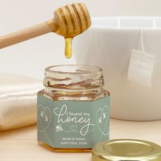 a jar of honey with a wooden spoon next to it