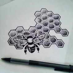 a drawing of a bee on top of a piece of paper next to a pen