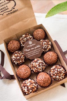 a box filled with chocolate covered donuts on top of a table