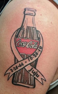 a tattoo on the back of a woman's thigh with a coca - cola bottle and ribbon around it