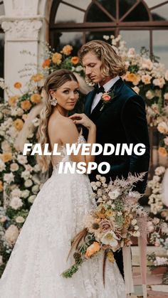 a man and woman standing next to each other in front of a flower covered arch