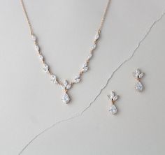 a necklace and earring set on a white surface