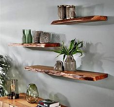 three wooden shelves with plants and vases on them