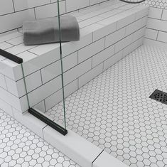 a bathroom with white tile and black grout