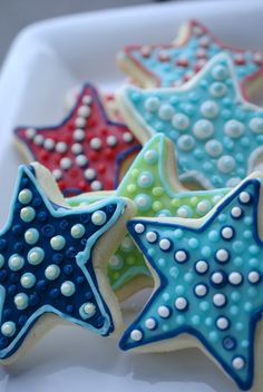 four decorated cookies in the shape of stars