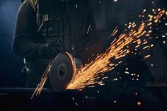 welder cutting metal with sparks in the dark