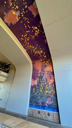 an artistic painting on the side of a wall in a building with purple and yellow colors