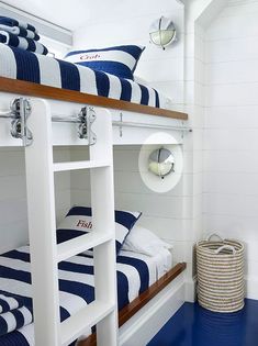 bunk beds with blue and white striped sheets in a small room on the bottom floor