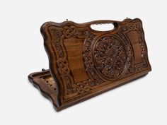 an intricately carved wooden purse on a white background with clippings to the side