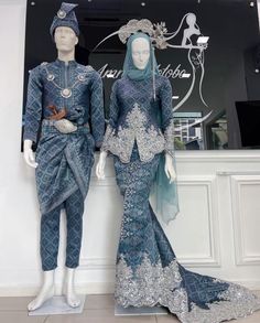 two mannequins are dressed in blue and silver outfits, one is standing next to the other