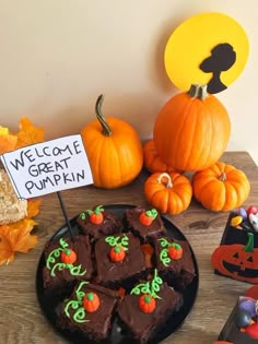 there is a plate of brownies on the table with pumpkins and jack - o'- lantern decorations