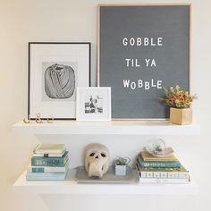 two shelves with books and pictures on them, one has a skull in the middle