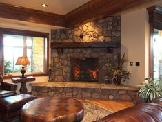 a living room with a stone fireplace and leather furniture