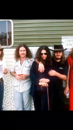 a group of people standing next to each other in front of a trailer