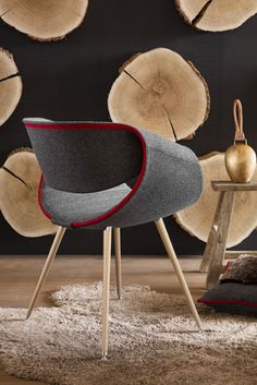 a chair and table in front of wood logs with an apple on the floor next to it