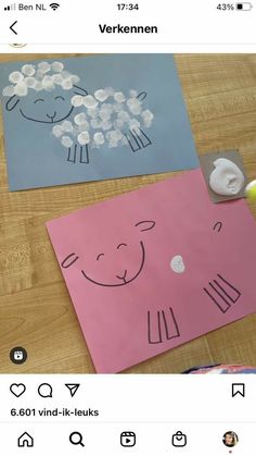 paper cut out to look like sheep and lambs on a table with other crafting supplies