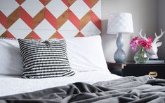 a bed with two lamps on each side and a checkered headboard above it