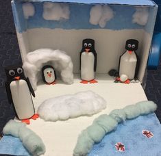 there are penguins that are standing in the snow and one penguin is laying on the ground