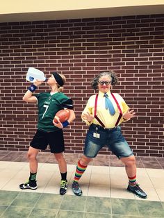 two people in costume standing next to each other on a sidewalk with brick wall behind them