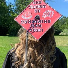 a woman wearing a red graduation cap that says the start of something new