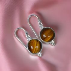 Earrings: Tiger Eye Gemstone Dangle Drop Earrings in 925 Sterling Silver, Elegant Silver Jewelry Gifts for Her. Note:- All kinds of stone are available, Please leave a message or a note. Main Stone: Natural Tiger's eye  Metal Purity: 925 Sterling Silver Gemstone Size : 7 MM Gemstone Shape : Round Total Weight: 2.0 to 3.0 gm ( approx ) -: Our Goal is 100% Customer Satisfaction :- -: We use Natural Gemstone :- -: All Products Description are 100% Exact:- Made In: Jaipur, India _._._._._._._._._._. Sterling Silver Round Earrings, Nickel Free Sterling Silver Round Earrings, Silver Sterling Silver Earrings With Round Stone, Sterling Silver Round Hallmarked Earrings, Classic Sterling Silver Earrings With Round Stone, Silver Gemstone Earrings With Round Stones, Silver Gemstone Round Stone Earrings, Round Sterling Silver Gemstone Earrings, Hallmarked Sterling Silver Round Earrings