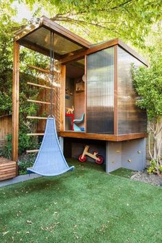 an outdoor play area in the backyard with a swing set and wooden structure on it