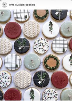 many decorated cookies are arranged on a white tablecloth with the words merry written in red, green and blue