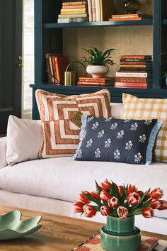 a living room filled with furniture and bookshelves covered in lots of different types of pillows