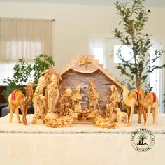 a nativity scene with figurines in the foreground and a christmas tree in the background