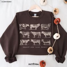 "This Unisex crewneck sweatshirt features \"support your local farmer.\" with a vintage set of cow illustrations. It is the perfect gift for cattle ranchers, cow lovers, homesteaders and more! Make sure to check out the other garment options below :) » O P T I O N S « ‣ Tshirt: https://www.etsy.com/listing/1484256374 » A B O U T « ‣ This item is made to order using direct-to-garment (DTG) printing technology. This digital process involves the printer inks being jetted or sprayed onto the textile by a print head after the garment goes through a pre-treatment machine to create a stronger bond between garment fibers and the pigmented inks. ‣ This is NOT screen printed NOR do we use heat transfer vinyl (iron-on). » S I Z I N G « ‣ Since we all have different bodies, some find the garments to b Farming Clothes, Support Your Local Farmer, Dairy Farming, Animal Sweater, Farm Clothes, Cute Country Outfits, Clothes Trendy, Vintage Farm, Sweatshirt Vintage