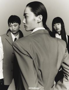 a group of young people standing next to each other in front of a white wall