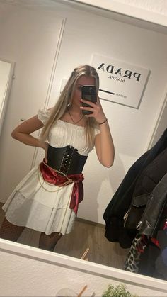 a woman taking a selfie in front of a mirror wearing a corset