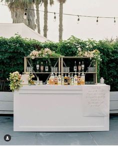 an outdoor bar set up with liquor bottles and flowers