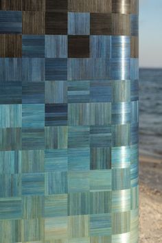 a tall metal pole sitting on top of a sandy beach