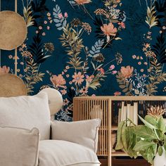 a living room scene with focus on the sofa and floral wallpaper, along with a plant