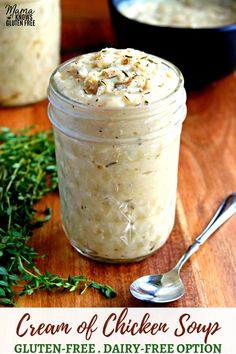 a jar filled with cream of chicken soup on top of a wooden table next to a spoon