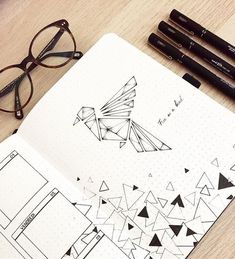 an open notebook with some drawings on it next to pens and eyeglasses,