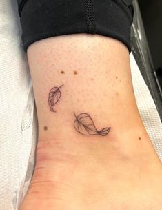 a woman's foot with a small tattoo on it