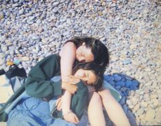 two women laying on the ground with their arms around each other