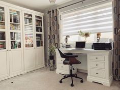 a desk with a laptop computer on it in front of a bookcase and bookshelf