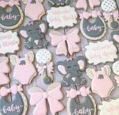 decorated baby shower cookies on a table with pink and gray decorations, including elephant ones